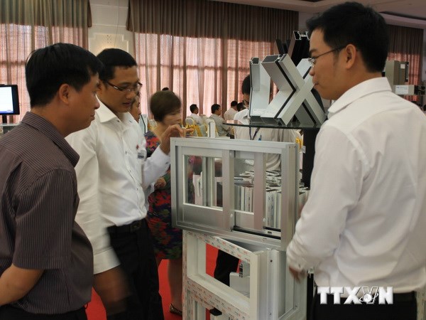 Các đại biểu tham quan các sản phẩm vật liệu xây dựng trưng bày bên lề hội nghị. (Ảnh: Quách Lắm/TTXVN)