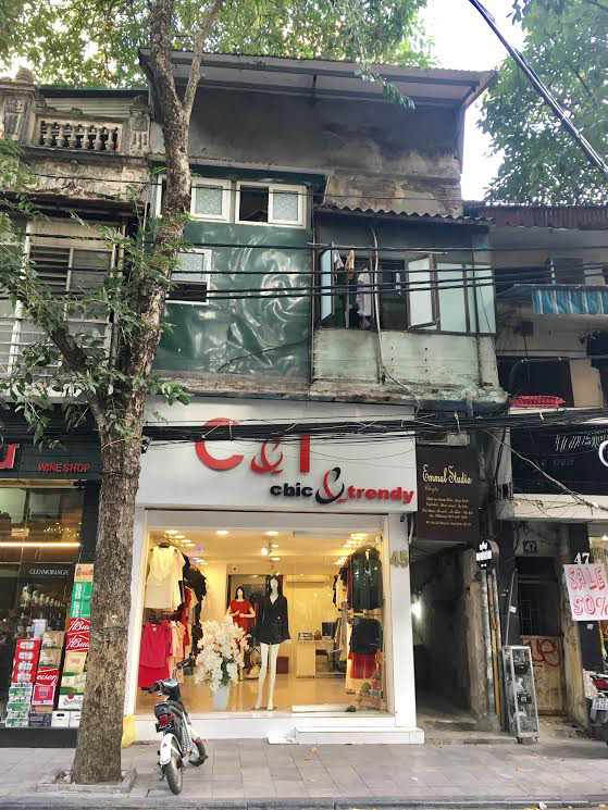 Cửa hiệu thời trang đèn biển bắt mắt không liên quan với kết cấu tổng thể phía trên.