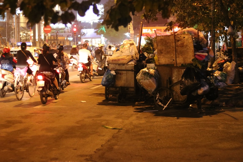 Điểm tập kết rác lấn ra lòng đường, ảnh hưởng đến việc di chuyển của các phương tiện tham gia giao thông.