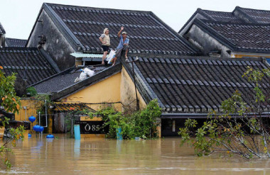 Người dân leo lên mái nhà cầu cứu ở Hội An - Ảnh Reuters