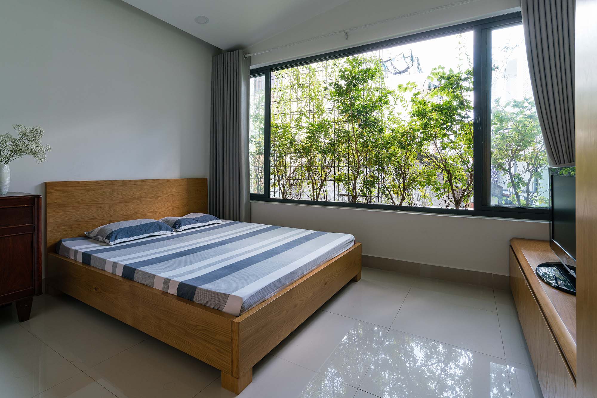 Nhà ít người nên chỉ có hai phòng ngủ trên tầng hai. Nhờ các mảng xanh ở mặt tiền và hông nhà, các phòng ngủ đều được tiếp xúc với thiên nhiên.