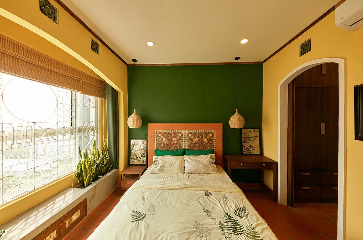 Trong phòng ngủ, giường làm từ gạch tàu và gỗ, đầu giường có ốp tấm mosaic gốm. Sau cửa kính, nhóm thiết kế bố trí thêm hệ song sắt để tăng cảm giác về một căn nhà Việt. Ảnh: Thiết Vũ.
